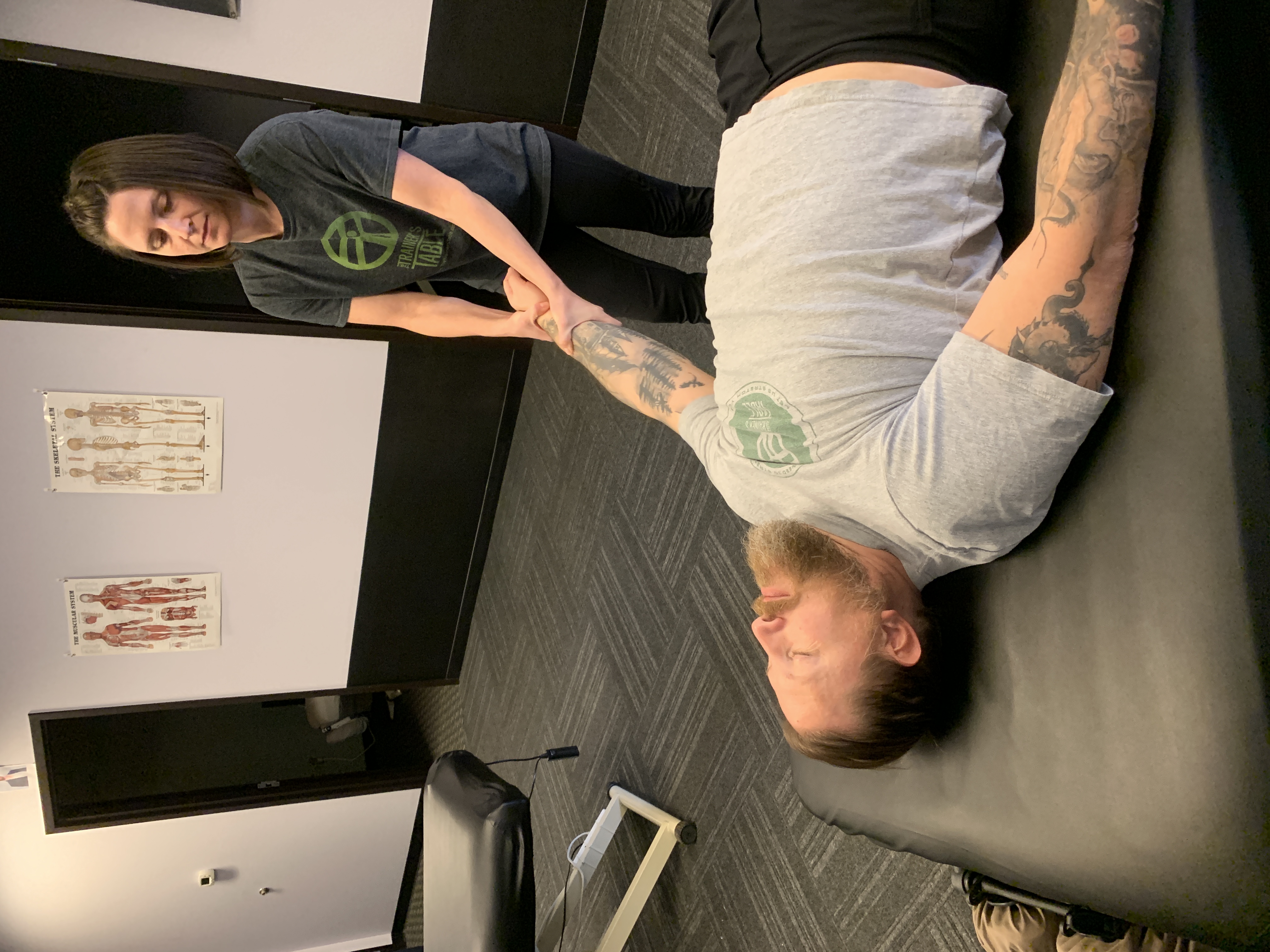 A therapist assisting a client's arm stretch