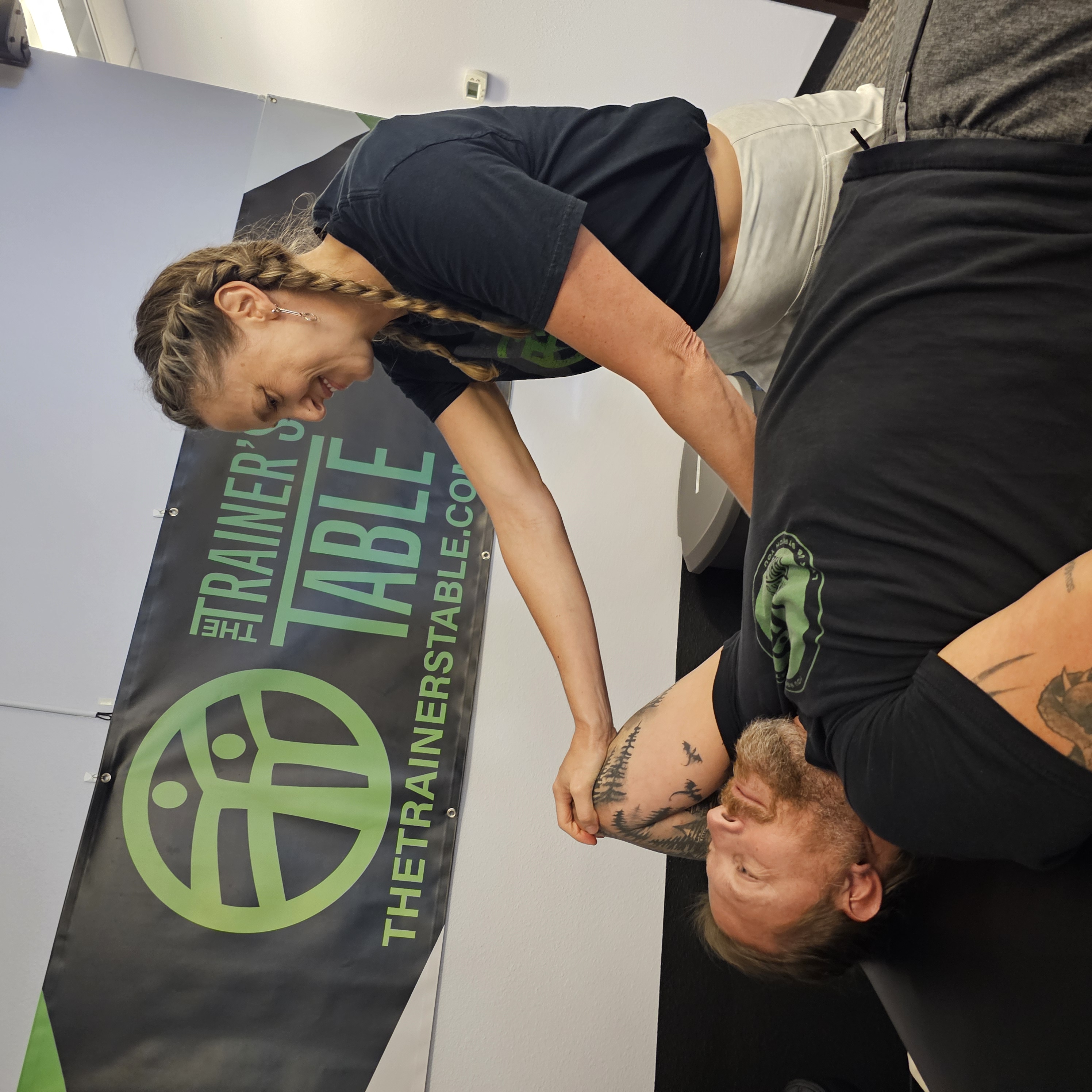 A therapist guiding a client's shoulder stretch